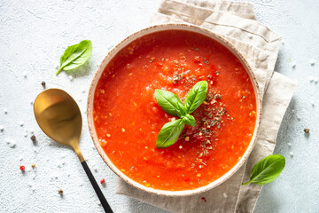 Tomato soup with spices and basil. Cold summer soup. Top view on white background. - obrazy, fototapety, plakaty