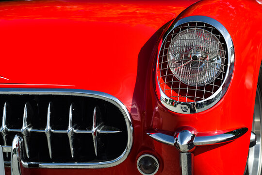 Closeup front bumper and headlight of the vintage retro red Chevrolet Corvette car