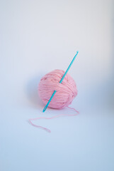 Pink threads with a ball lie on a white background.