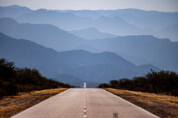 Horizontal format photograph of the national highway number 40 with silhouettes of mountains in the background