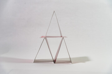 cards placed in the form of a pyramid on a white table