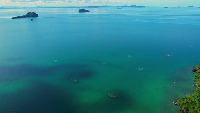 Drones are flying over the beautiful sea, many islands in the background, fish traps and squid traps on the sea, the fishing industry in Ao Kram, Chumphon, Southern Thailand. 4K drone footage
