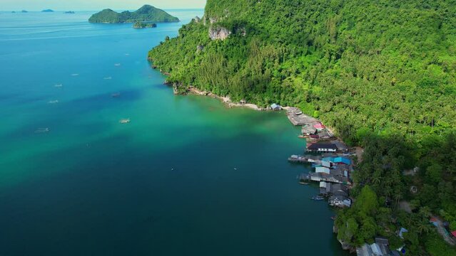 Fishing village at Ban Ao Kram. Ban Ao Kram has a homestay for tourists to stay and learn about the lifestyle of fishermen. Tropical sea at Chumphon, Thailand. Cinematic drone shot. 4k
