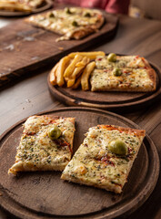 pizza crijiente con muzzarella, salsa de tomates, oregano y aceitunas junto a plato de papas fritas