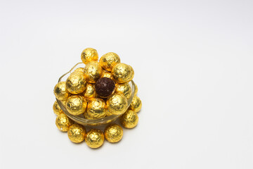 Soccer Ball-shaped chocolates in gold foil rotating on a white background