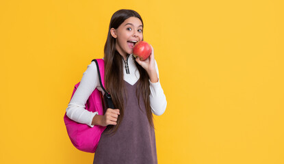 amazed child with school backpack and apple on yellow background