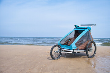 Empty bicycle trailer with front wheel at the beach
