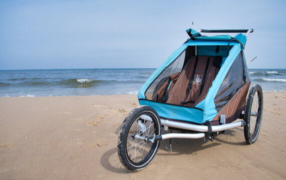 Empty bicycle trailer with front wheel at the beach
