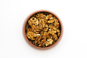 Walnut in a clay bowl on a white background. Close-up