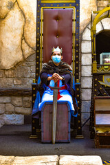 king with chinstrap sitting on throne