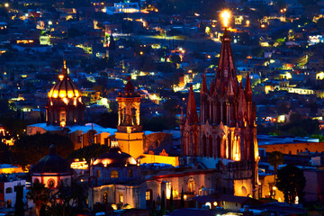 Obraz premium cityscape with parish at night with cross of light in the top, blue hour in san miguel de allende guanajuato 