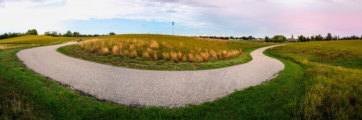 Tranquil hilly meadow gentle sunset landscape with curved footpaths at A.E. Wilson Park in Regina, Saskatchewan, Canada