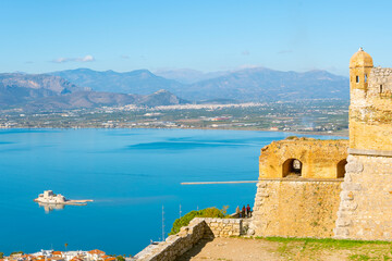 View from the ancient fortress of Palamidi above the Aegean Sea and the town of Nafplio, with the Bourtzi Castle in view in the blue waters of the bay.