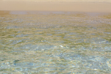 Beautiful sea water with ripples and sandy shore