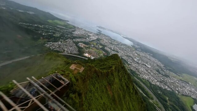 FPV drone shot following down a mountain ridge, in foggy Hawaii, USA - POV aerial