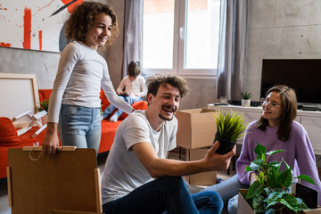 family moving in apartment parents with kids opening box with stuff