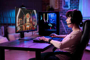 Modern blogger having fun with video games play on pc, streaming live action tournament online. Young female gamer playing rpg championship with multiple players, gaming competition.