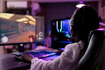 Female streamer having fun with video games online play, playing action game tournament on computer. Woman enjoying esport gaming championship on pc stream, multiplayer video game.