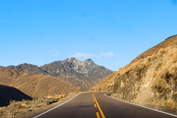 Estrada entre as montanhas com céu azul no Peru
