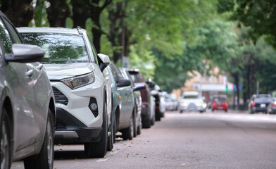 Cars parked in line on city street side. Urban traffic concept - Powered by Adobe