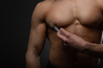 Muscular man with a syringe in his hand. User of anabolic steroids for strength training