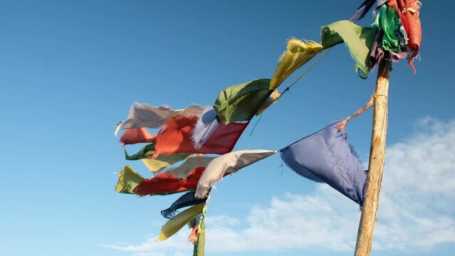 Religious tibetan buddhist prayer flags are flutter in the wind on blue sky background.