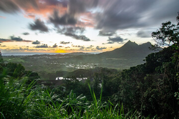 Panoramic aerial image from the Pali Lookout on the island of Oahu in Hawaii. With a bright green rainforest, vertical cliffs and vivid blue skies.