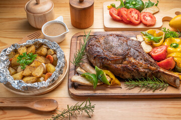 Barbecue Tomahawk Steak on wooden plate.Grilled tomahawk ribeye steak with baked potatoes...
