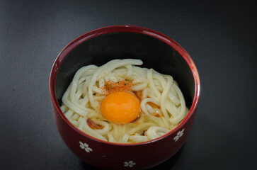 茹でたてうどんに卵と醤油と七味をのせて