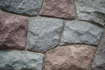 Wall of stones. Beautiful wall made of colorful stones. Decorative wall from house outdoors.