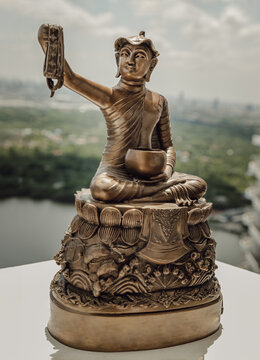 Bronze figurine of Phra upagupta or Phra bua khem statue with nature background. Selective focus.