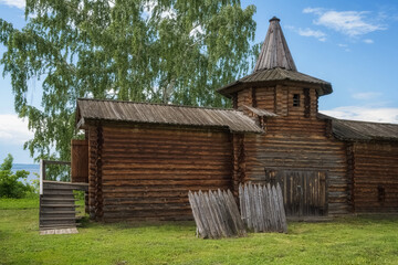 Fragment of an ancient log fortress with a tower and a porch on the banks of the Kama River in summer. Ural city Osa, Russia