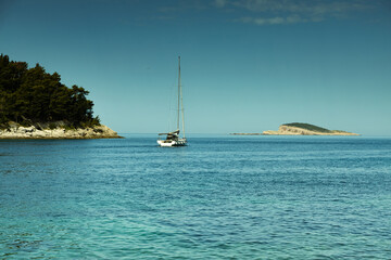 Sea landscape, Adriatic Sea, Croatia, island in the horizon, a small sailboat sets out from the bay to the sea