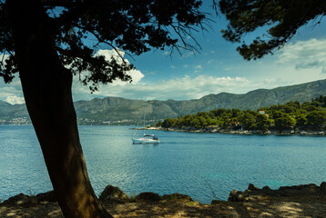 Sea landscape, Adriatic Sea, Croatia, mountains  in the horizon, a small sailboat sets out from the bay to the sea