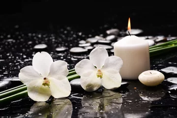 Tuinposter Still life of with  Two white orchid  ,candle and zen black stones and green plant on wet background,  © Mee Ting