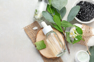 Aloe vera slices and moisturizer on a light background.