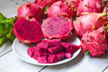 dragon fruit slice and cut half on white plate with pitahaya background , fresh pink red purple dragon fruit tropical in the asian thailand healthy fruit concept