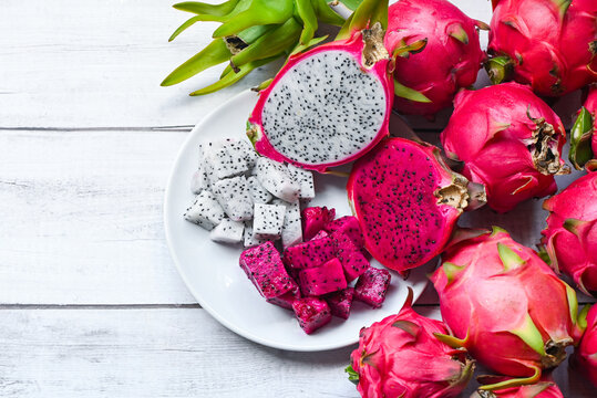 fresh white and pink red purple dragon fruit tropical in the asian thailand healthy fruit concept, dragon fruit slice and cut half on white plate with pitahaya background