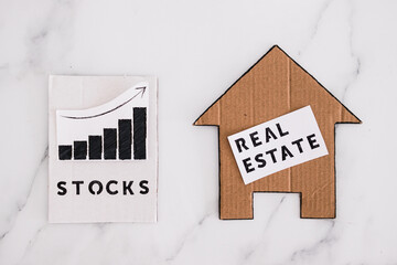 investment opportunities and building wealth, house icon next to stock market stats symbol of...