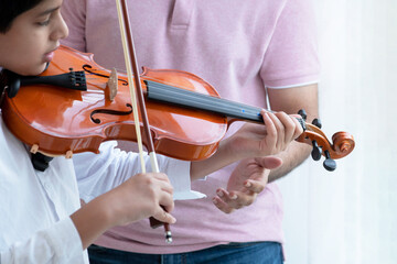 Indian father teaches his son to play violin at home, educate music skill, classical education