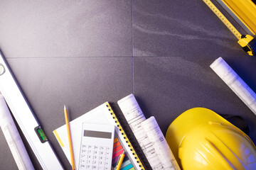 Contractor theme. Plans,  notebook and tool kit of the contractor: yellow hardhat, libella, saw and...
