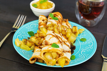 Pancakes with apples on dark background