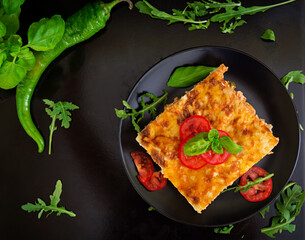 Classic Lasagna with bolognese sauce on dark background