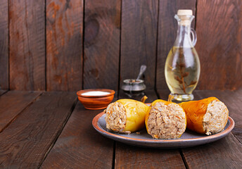Colorful stuffed peppers with rice and minced meat on wooden background.