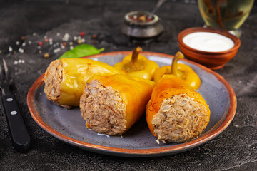 Colorful stuffed peppers with rice and minced meat on wooden background.