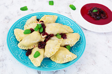 Delicious dumplings with cherry on white background