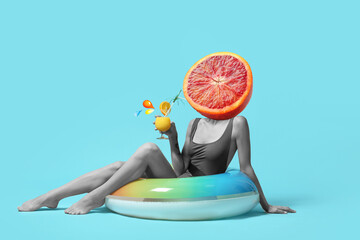 Young woman with cocktail and inflatable ring on color background - obrazy, fototapety, plakaty