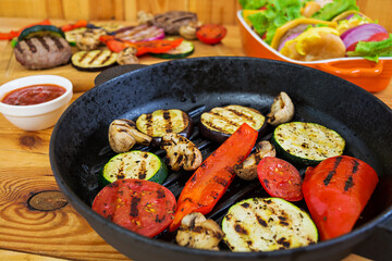 Grilled vegetables and handmade burger. Zucchini, eggplant, mushrooms, pepper on the grill. Top view