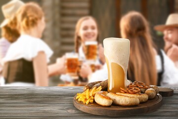 Glass of fresh beer and snacks on table outdoors. Oktoberfest celebration