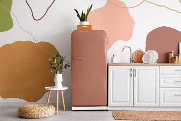 Interior of stylish kitchen with retro fridge, counter and houseplants